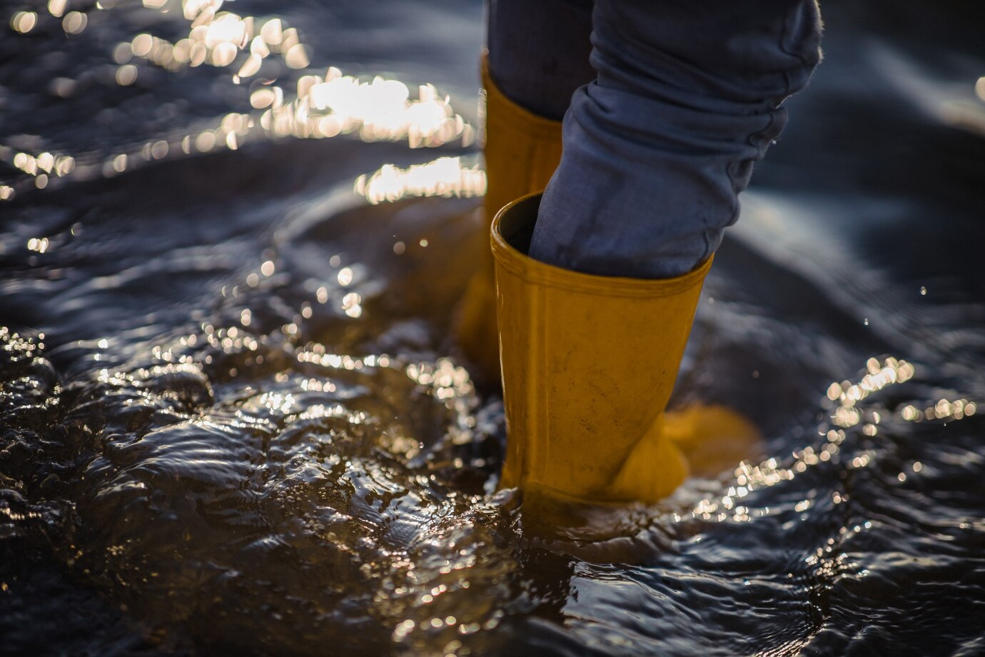 person-blue-denim-jeans-yellow-boots-standing-water_417767-346