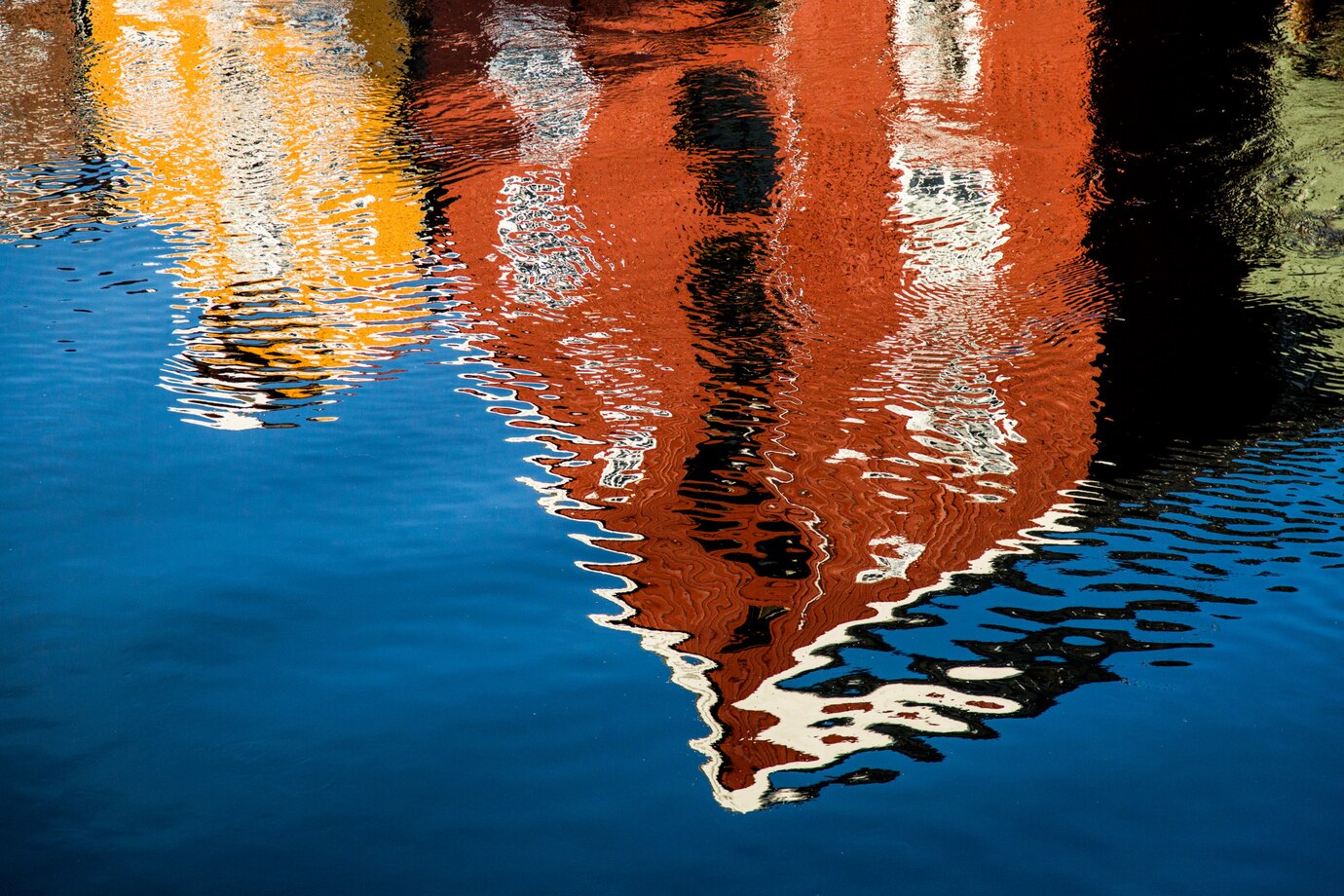 red-yellow-building-reflecting-lake_181624-6197